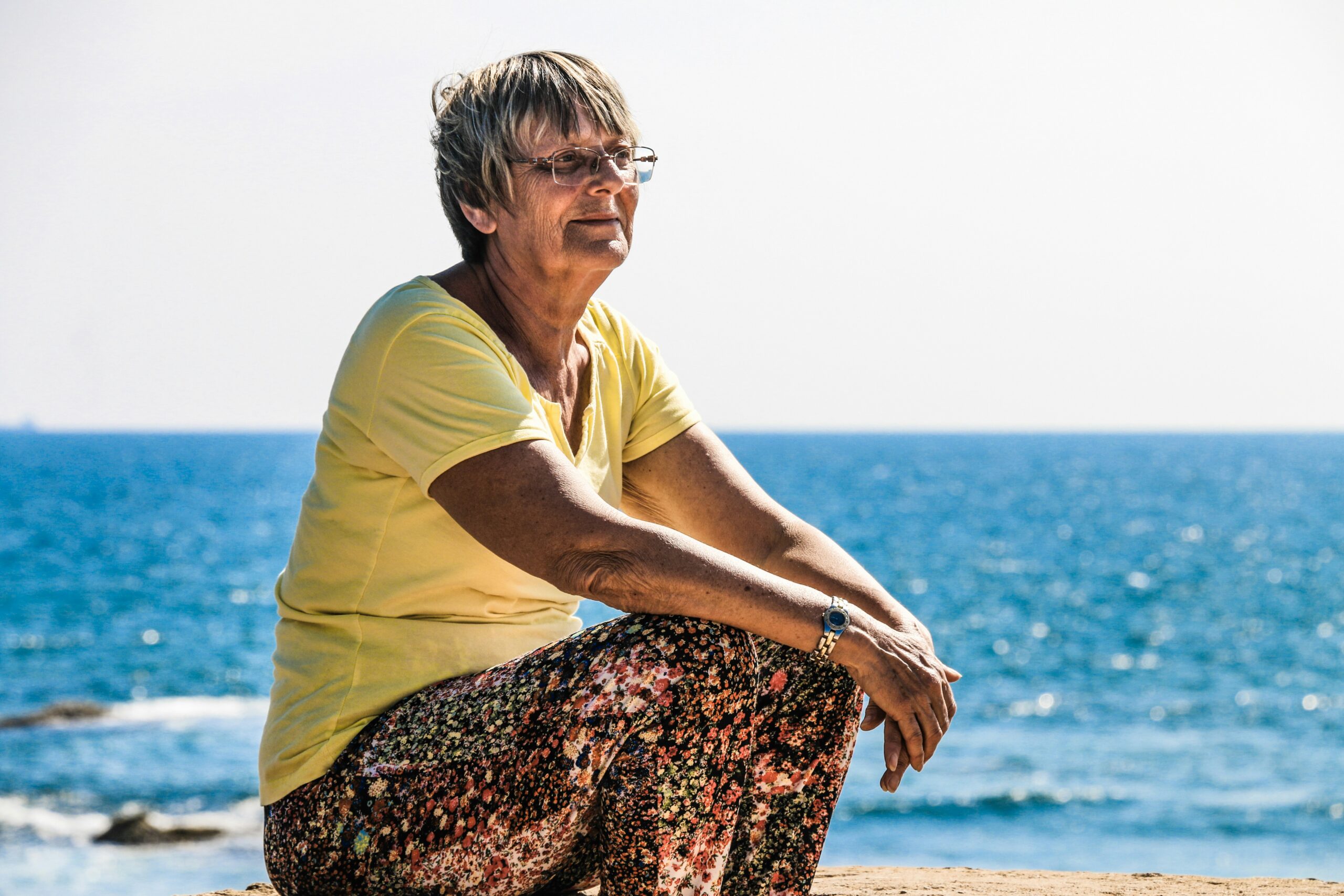 Senior citizen sitting by the ocean